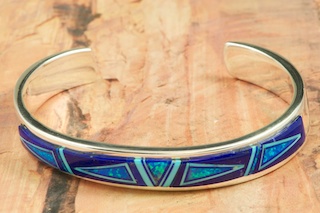 Stunning Bracelet featuring Genuine Blue Lapis and Black Jade inlaid in Sterling Silver. Beautiful Fire and Ice Lab Opal Accents. Heavy gauge Sterling Silver Bracelet Designed by Navajo Artist Calvin Begay. Signed by the Artist.